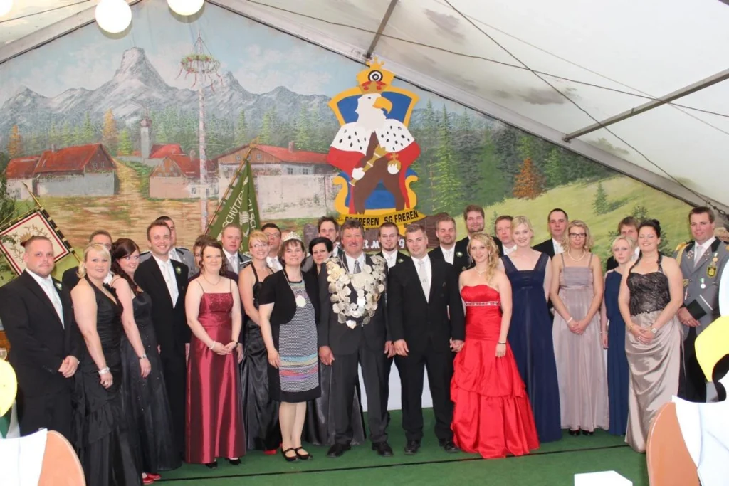 Gruppenfoto der Schützengesellschaft Freren beim Schützenfest. Festlich gekleidete Mitglieder posieren vor einer festlichen Kulisse mit dem Vereinswappen. Ein Highlight des kulturellen Lebens in Freren, das Tradition und Gemeinschaft feiert.
